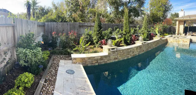 Raised stone planter wall along the pool