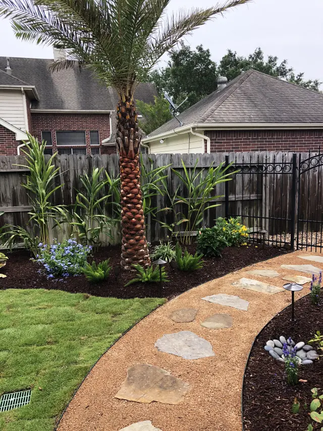 Palm bed and stone steppers along the fence