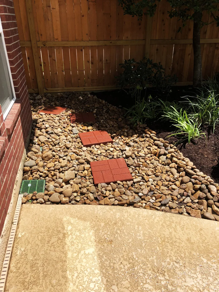 River-rock drainage bed installed by Trophy to route water away from the home